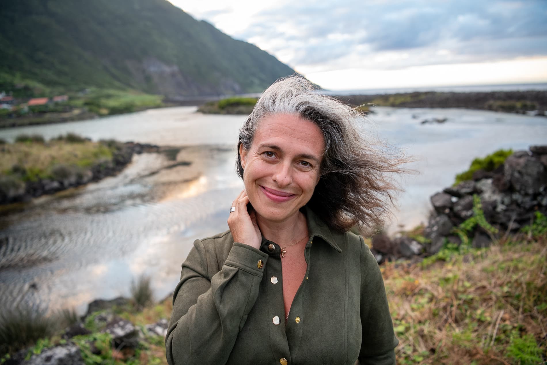 Inês beside the ocean and volcanic coastline on São Jorge